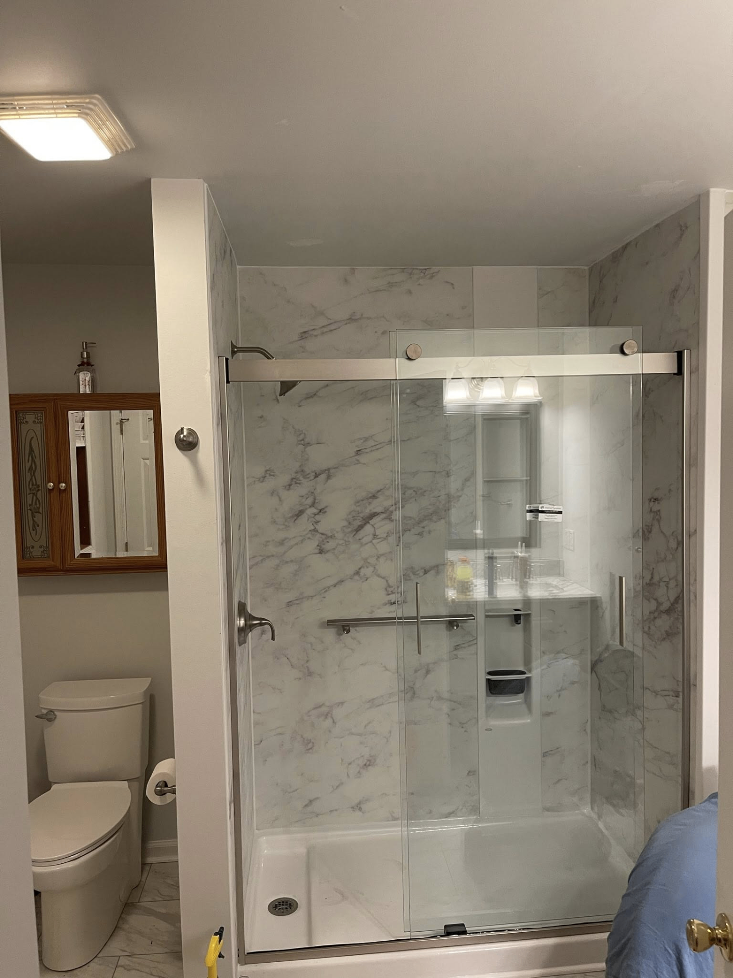 Bathroom remodel with marble-look shower and glass enclosure